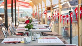 Die Terrasse ist anlässlich des Brunchs zum Schweizer Nationalfeiertag im Berggasthaus Edelwyss mit Schweizer Flaggen geschmückt.