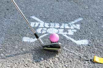 A worker of the tourist information in Glarus giving a golfer his equipment for Urban Golf