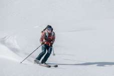 Skiier glides through untouched deep snow in the Glarus region