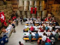 Besucher geniessen den traditionellen 1.-August-Brunch in einer festlich dekorierten Scheune