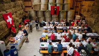 Besucher geniessen den traditionellen 1.-August-Brunch in einer festlich dekorierten Scheune