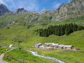 Bösbächi alpine farm buildings and mountain stream in alpine landscape above Braunwald in Switzerland