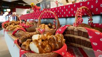 Frisch gebackenes Brot und Zopf in dekorierten Brotkörben am Frühstücksbuffet