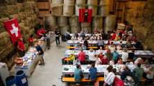 Besucher geniessen den traditionellen 1.-August-Brunch in einer festlich dekorierten Scheune