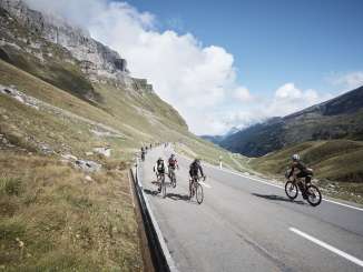 Road cyclists climbing the Klausen Pass during the Klausen Monument against a spectacular Alpine backdrop.